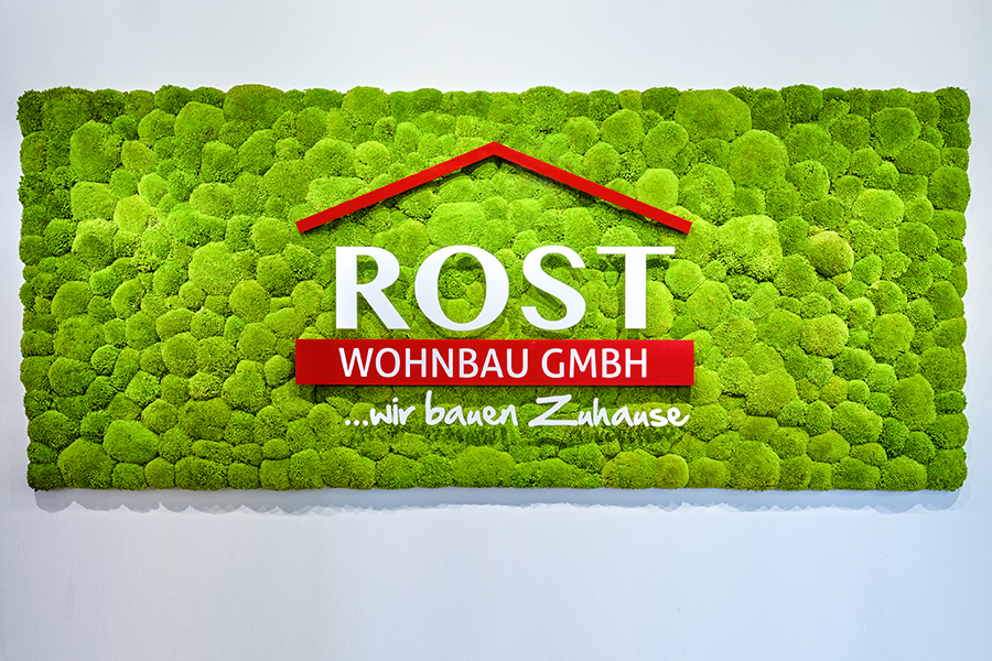 Rost-Wohnbau Energiesparhaus Immobilie Mehrfamilienhaus Bild mit Rasen