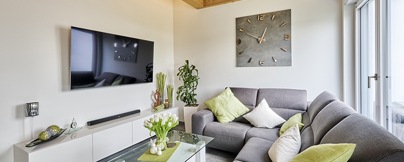 Rost-Wohnbau Energiesparhaus Immobilie Wohnzimmer mit grauem Sofa